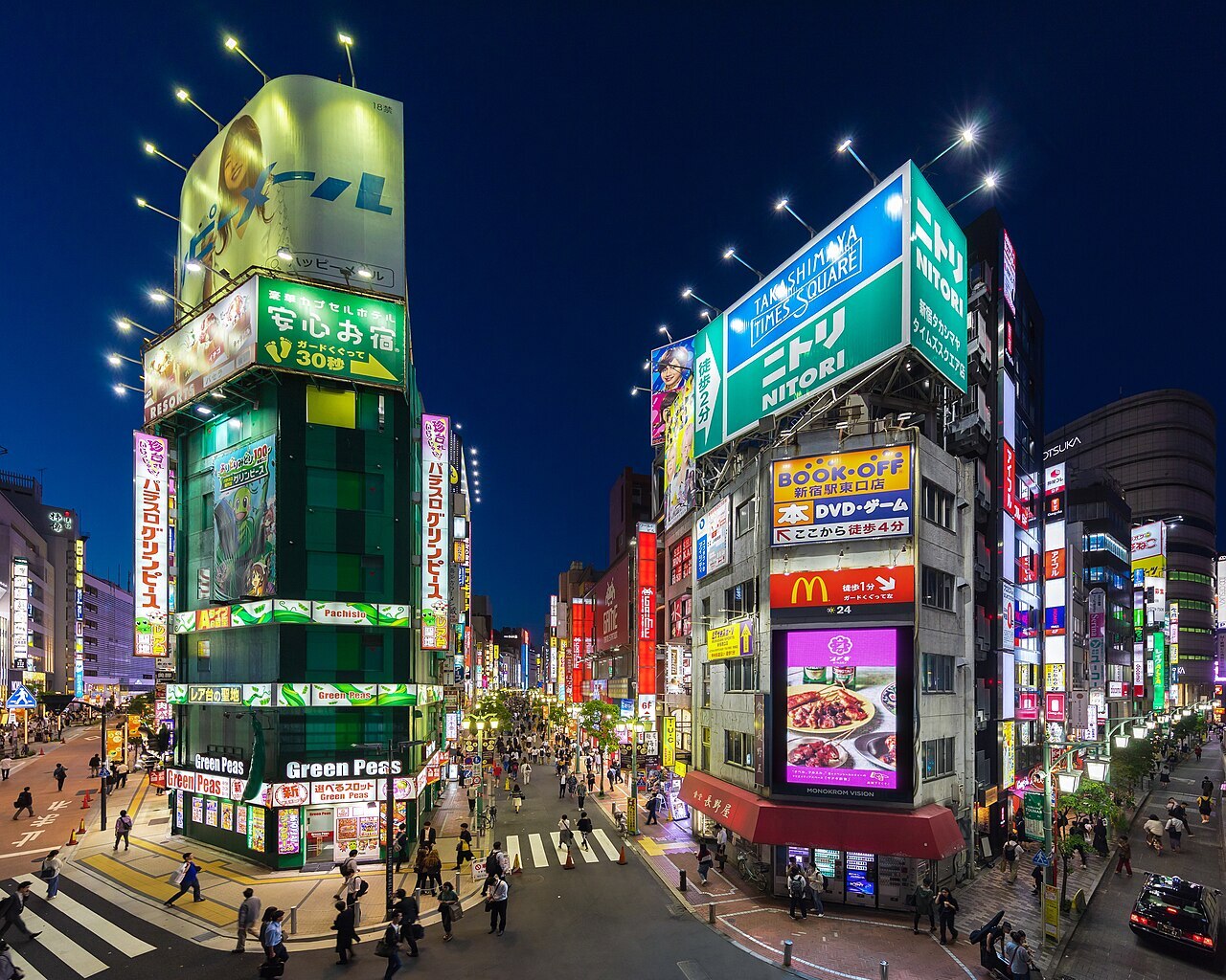 Facades of Green Peas pachisuro parlor and Naganoya restaurant, colorful neon street signs at blue hour, view from Koshu-kaido Avenue, Shinjuku station JR East. Entertainment district in Shinjuku, Tokyo, Japan.