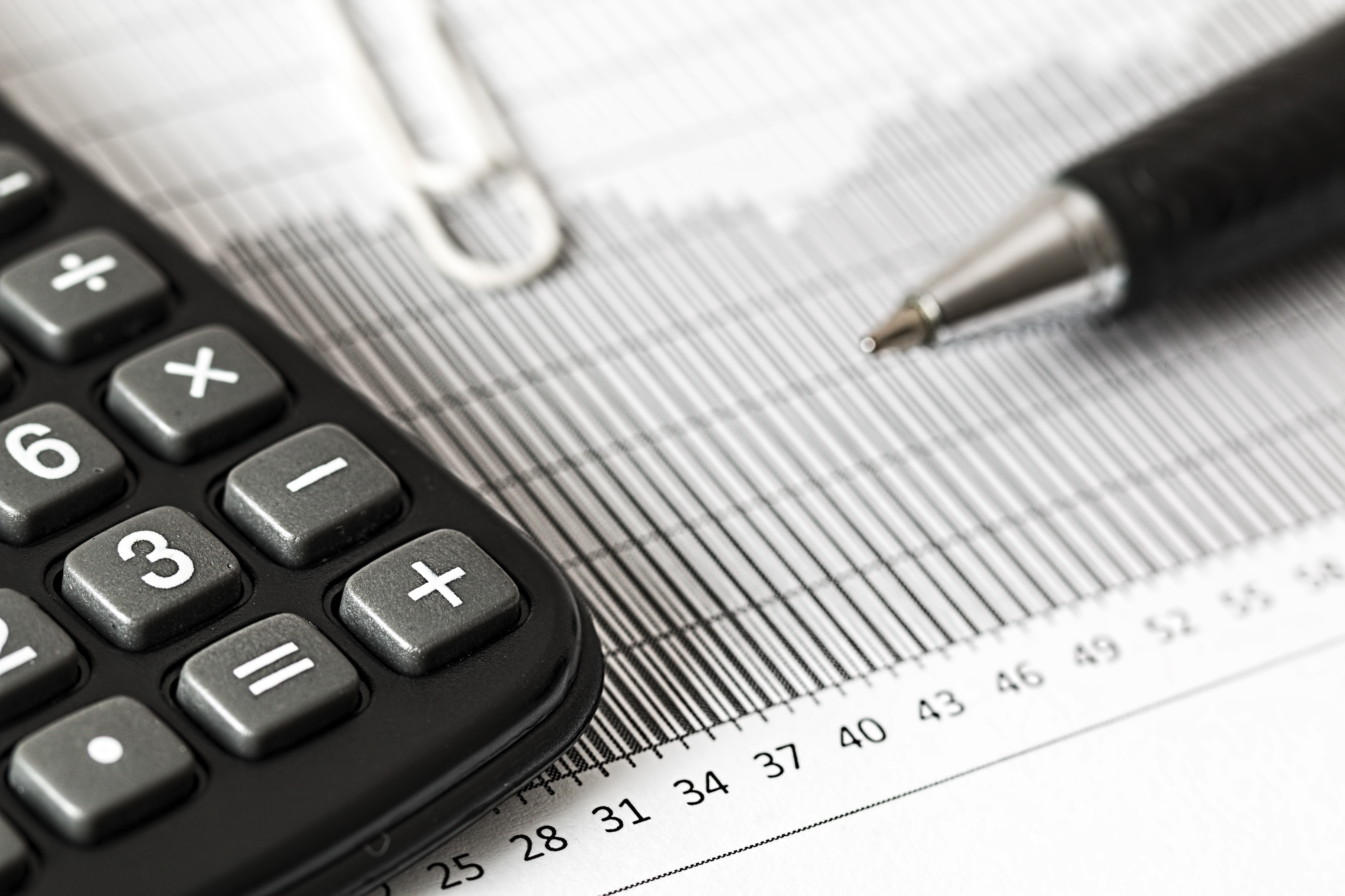 Picture of calculator and pen on top of charts